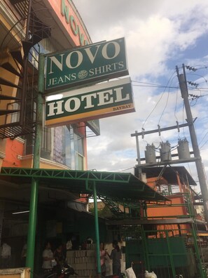 Un letrero de hotel con la inscripción "NOVO Jeans Shirts" y "HOTEL BAYBAY".