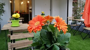 A patio area with wooden furniture, potted plants, and string lights. - B&B Cristiano (Rende)