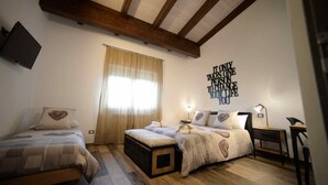 A bedroom with a large bed, a smaller bed, a nightstand, a lamp, and a wall with a motivational quote. - B&B Cristiano (Rende)