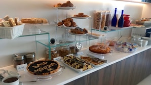Un buffet proposant une variété de plats, notamment des pâtisseries, des desserts et des condiments.