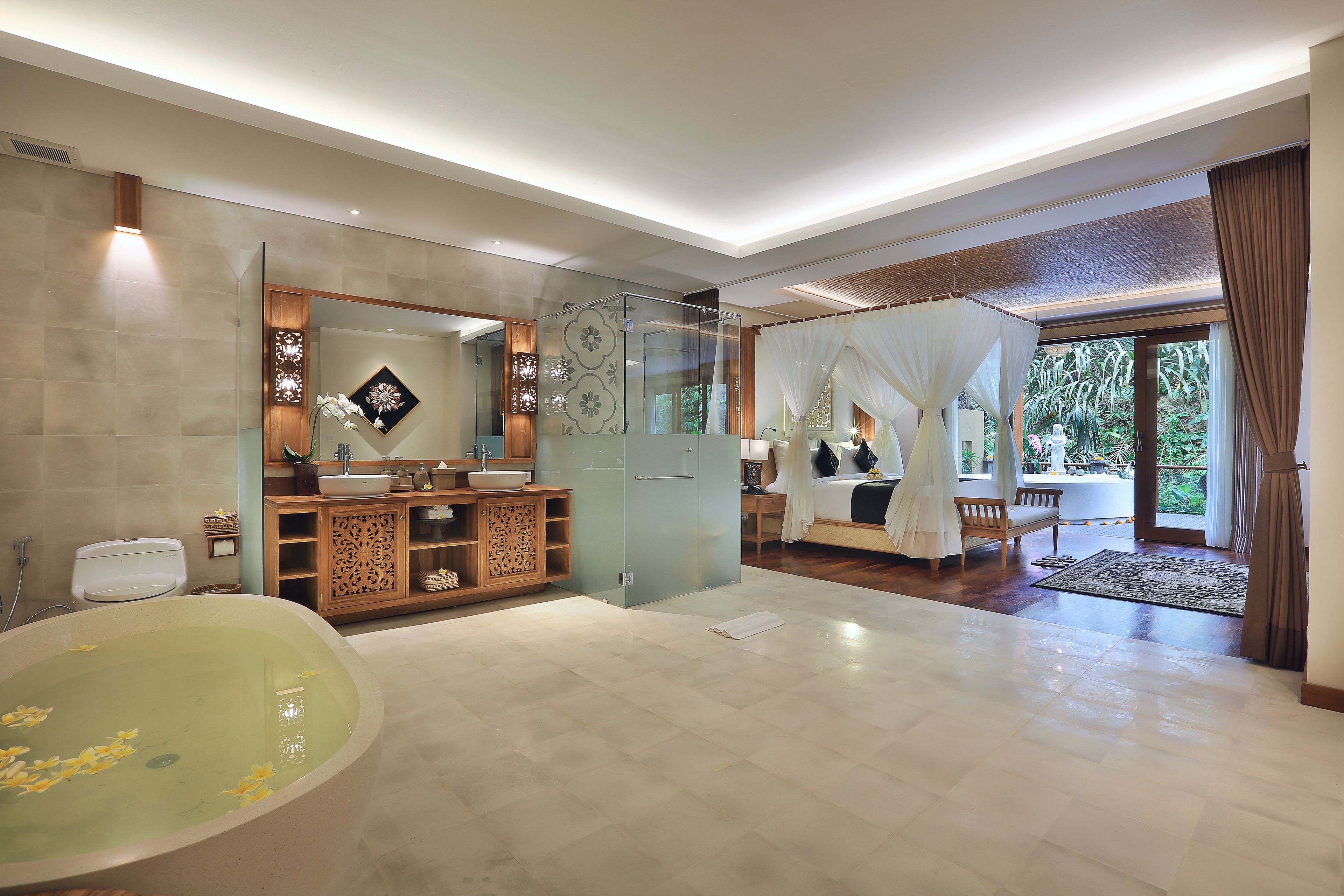 A spacious bathroom with a large bathtub, a glass shower enclosure, and a vanity with multiple sinks.