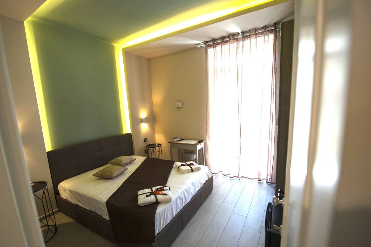 Een hotelkamer met een groot bed, een bureau en een stoel.