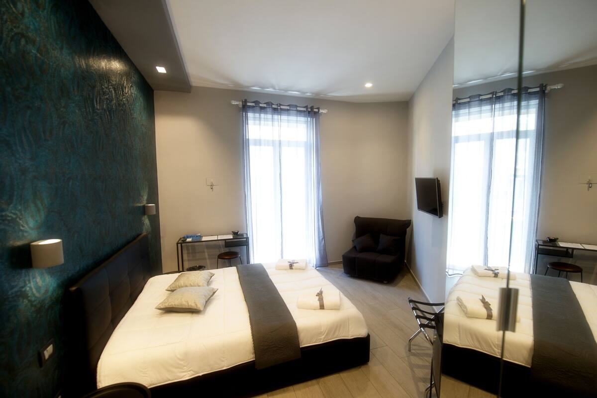 Een moderne hotelkamer met twee bedden, een bureau, een stoel en een televisie.