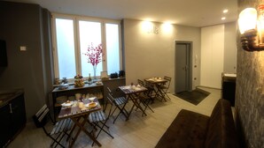 A compact living space with a dining area, kitchenette, and a door leading to another room.
