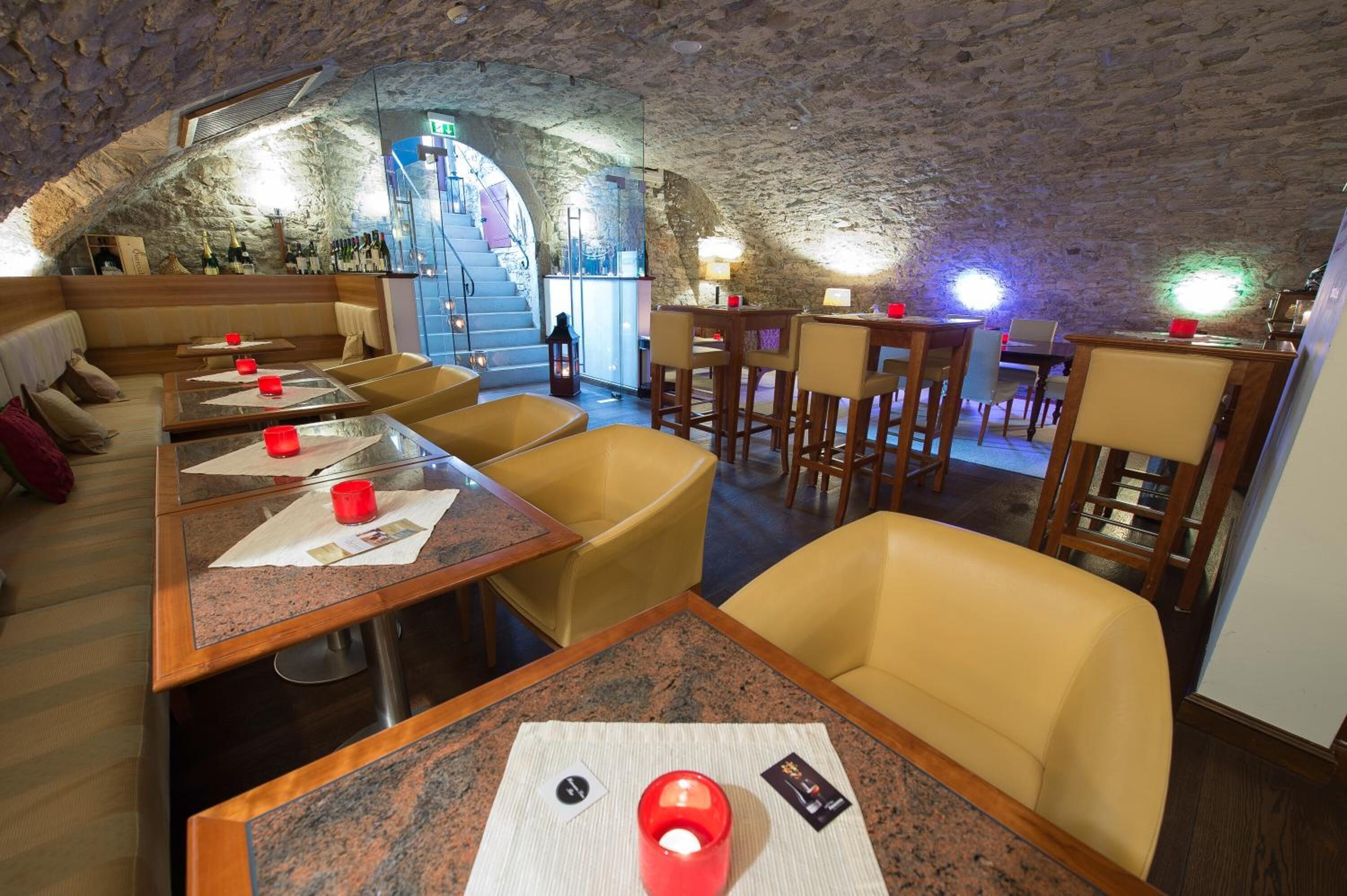 Un restaurante con paredes de piedra, mesas de madera y sillas amarillas.