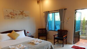 A hotel room with a bed, two chairs, a window with curtains, and a door leading outside. - The Bay Mui Ne (Mui Ne)