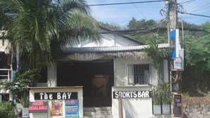 A building with a sign reading "The BAY SPORTS BAR" and another sign indicating "ROOM AVAILABILE". - The Bay Mui Ne (Mui Ne)