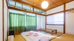 A traditional Japanese room with tatami flooring, a futon bed, a shoji screen, and a wooden desk. - Guesthouse Asobi Factory - Hostel (Fujikawaguchiko)