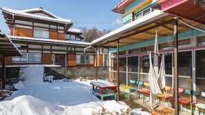 A traditional building with a covered outdoor seating area. - Guesthouse Asobi Factory - Hostel (Fujikawaguchiko)