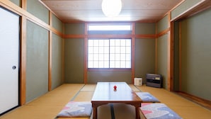 A traditional Japanese room with tatami flooring, a low wooden table, and a shoji screen window. - Guesthouse Asobi Factory - Hostel (Fujikawaguchiko)