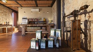 Eine rustikale Bar mit Holzbalken, Steinwänden und verschiedenen Flaschen und Kisten mit dem Aufdruck 'Grazia'.