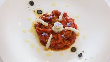 A plate of food with a sauce, garnishes, and olive oil.