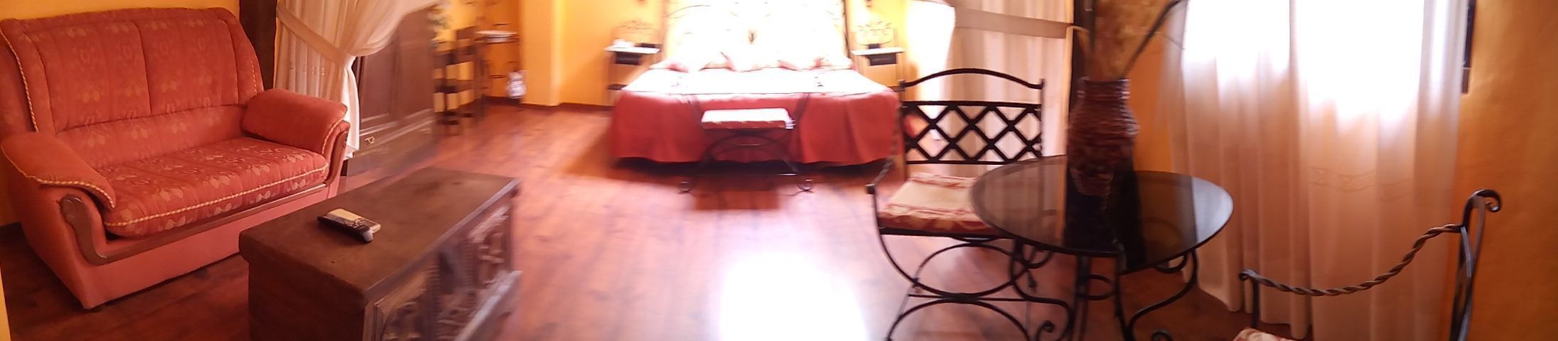 Una sala de estar con un sofá, una mesita, una mesa de vidrio y una silla.