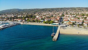 Vue aérienne d’une ville côtière avec un port de plaisance, une jetée et une plage.