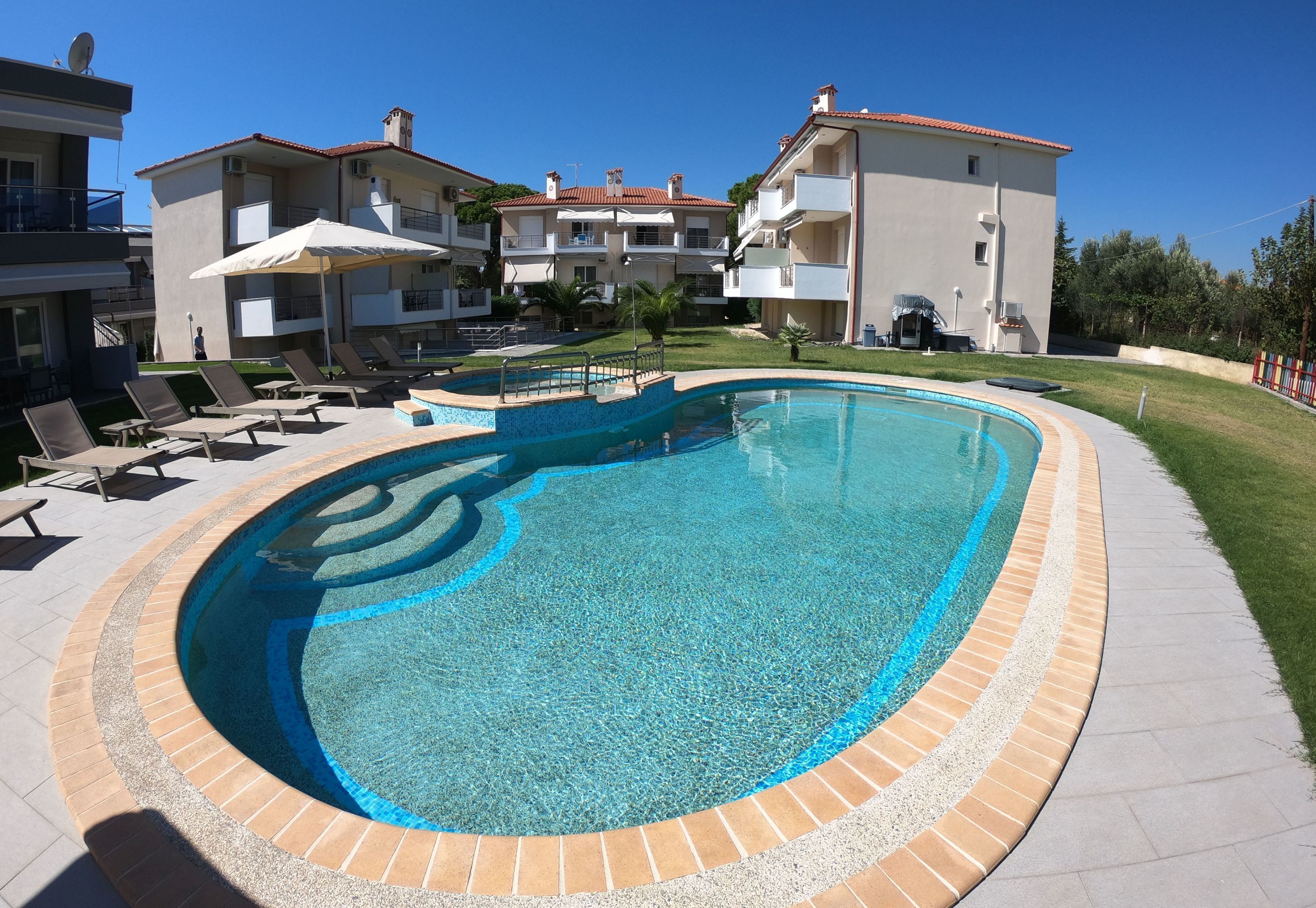 Una piscina al aire libre de temporada, sombrillas