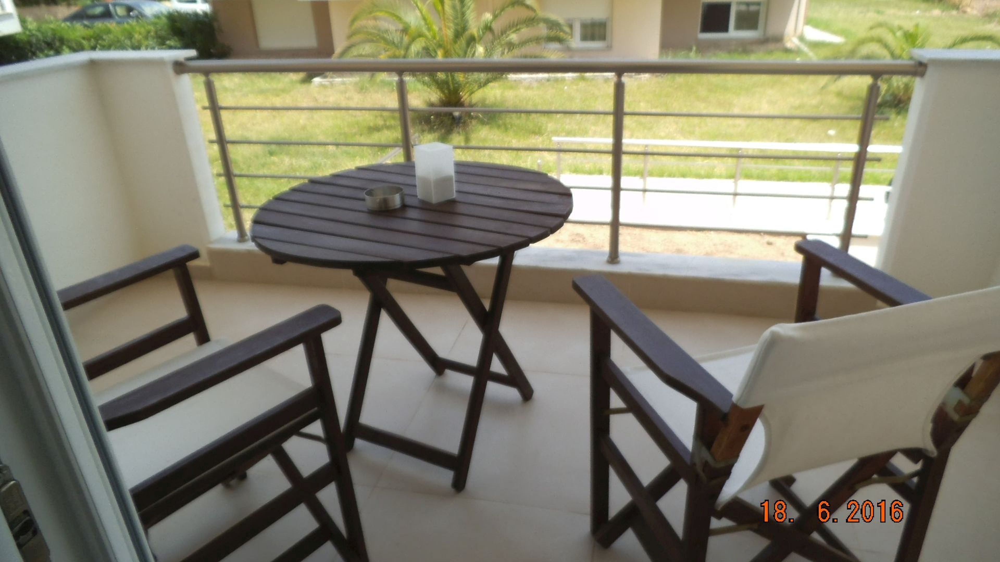 A balcony with a round table and two chairs.