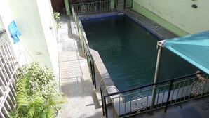 A swimming pool with a tiled deck and metal railings. - Koltol Guest House (Ibadan)