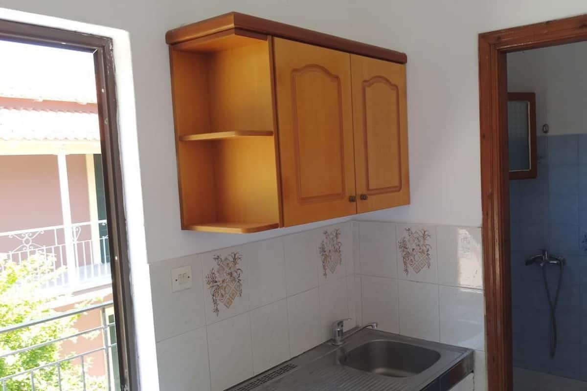 Eine Küche mit Spüle, Holzschränken und dekorativen Fliesen.