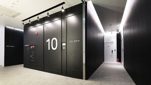 A modern elevator with directional signs indicating floors 10 and 11. - Hotel yaja wirye (Seongnam)