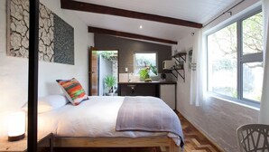 A bedroom with a bed, a bedside table, a chair, and a window. - Lemon tree Studio Stellenbosch Central (Stellenbosch)
