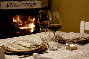 A dining table set with plates, glasses, and a candle.