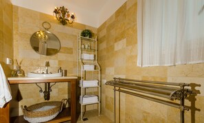 A bathroom with a sink, mirror, towel rack, and a towel drying rack. - Naomi's (Rosh Pinna)