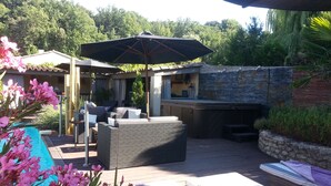 An outdoor patio with a seating area, a pool, and a stone wall. - Chambres d'Hôtes de la Ferrage (La Tour-d'Aigues)