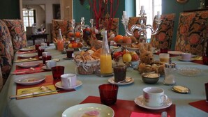 Un buffet de petit-déjeuner proposant une variété d’aliments et de boissons, notamment des fruits, des viennoiseries et un ours en peluche.