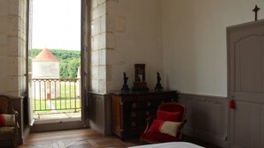 Une pièce avec une commode en bois, une chaise rouge et une porte.