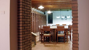 A dining area with a brick archway, wooden ceiling beams, and a tiled floor. - Hotel Bed & Wine (Negrar)