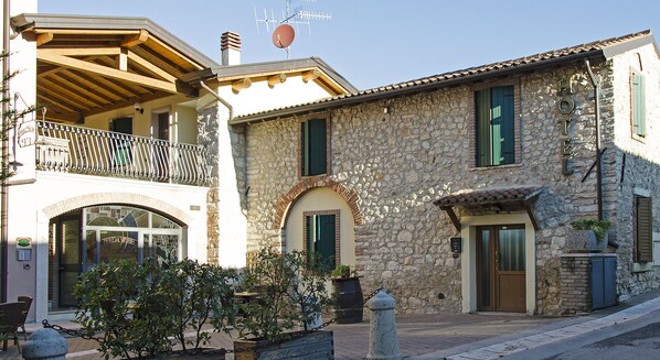 A stone building with a balcony, a door, and a window. - Hotel Bed & Wine (Negrar)