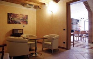 A cozy room with a wooden ceiling, a painting of a park, a radio, and a checkered floor. - Hotel Bed & Wine (Negrar)