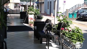 Un área de estar al aire libre con sillas y plantas en macetas.