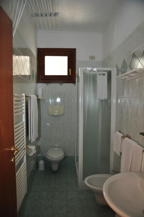 Une salle de bain comprenant des toilettes, un espace douche et un lavabo.