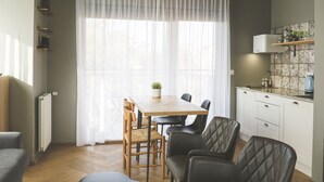 Una cocina moderna con una mesa de madera, sillas y un horno empotrado.