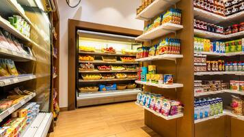 Un supermercado con estantes repletos de diversos productos alimenticios, entre ellos frutas, verduras y productos envasados.