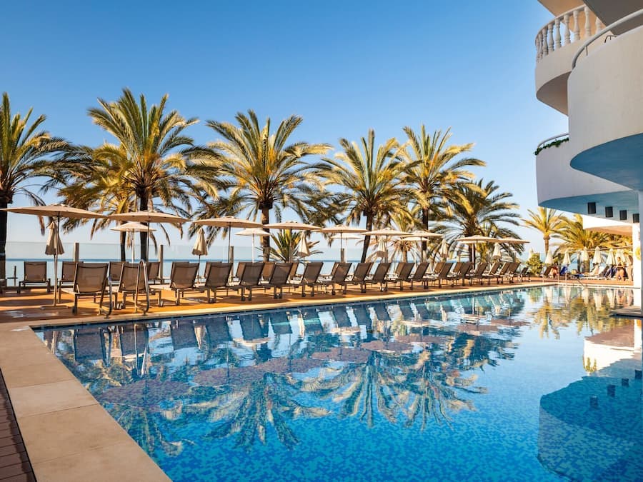 Een buitenzwembad, ligstoelen bij het zwembad