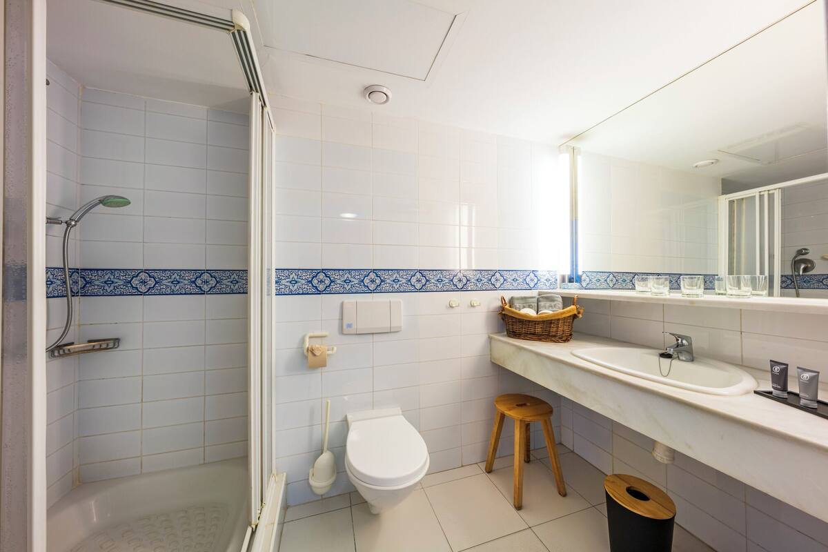 A bathroom with a shower, toilet, and sink.
