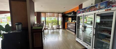 A spacious indoor area with a seating area, a refrigerator, and a counter.