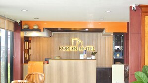 A reception desk with a sign reading "BORDIN HOTEL" and a modern interior design. - Bordin Hotel (Ubon Ratchathani)