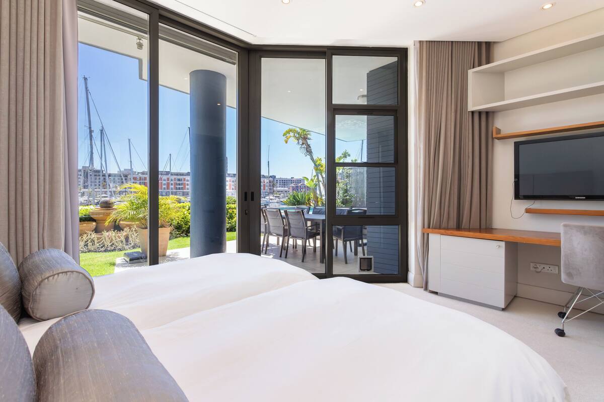 Une chambre d’hôtel moderne, dotée d’un grand lit, d’un bureau et d’une télévision.