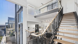 A modern interior with a staircase, large windows, and a balcony. - Mountain Marina Luxury Apartments (Cape Town)