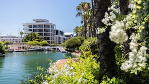 A waterfront hotel with a modern design, a bridge, and lush greenery. - Mountain Marina Luxury Apartments (Cape Town)