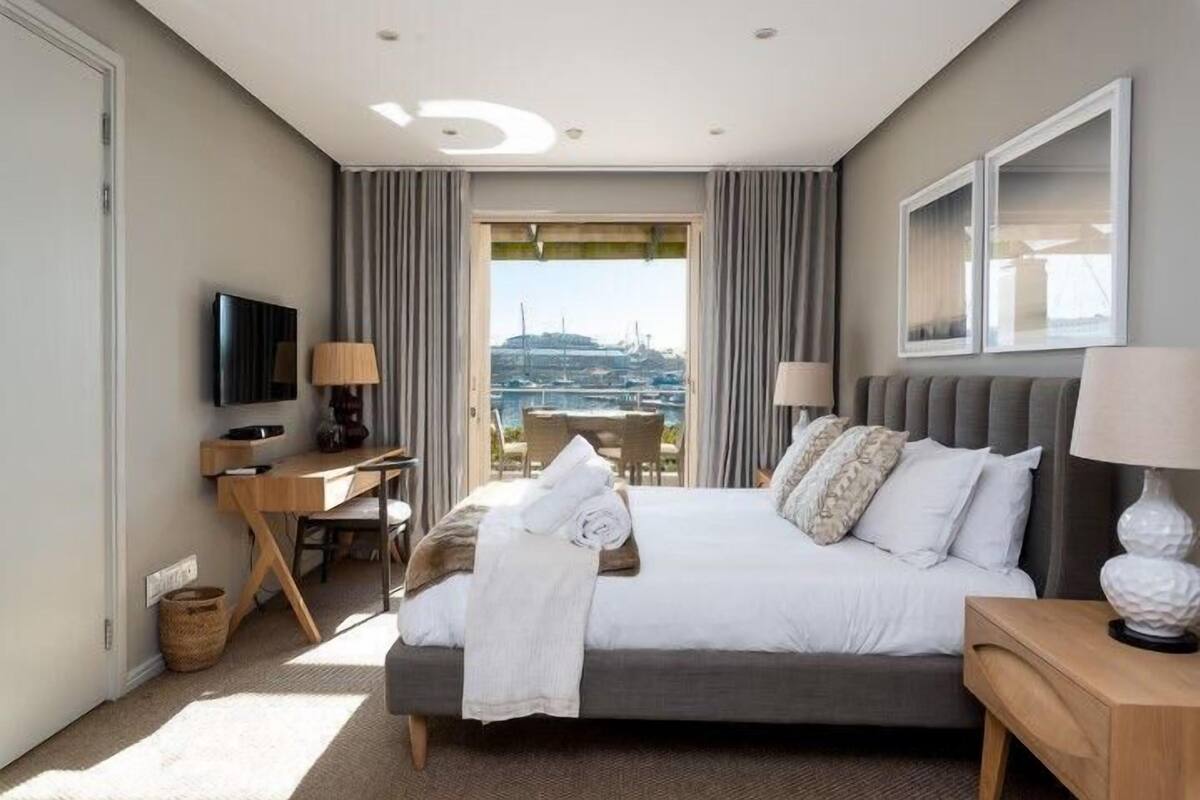 Une chambre d’hôtel avec un lit, un bureau, une télévision et une vue sur la ville.
