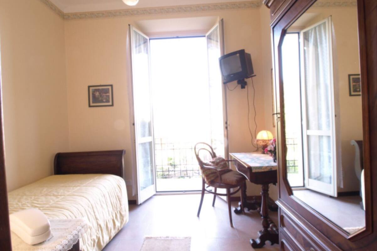 Une chambre à coucher avec un lit, un bureau, une chaise et un téléviseur.