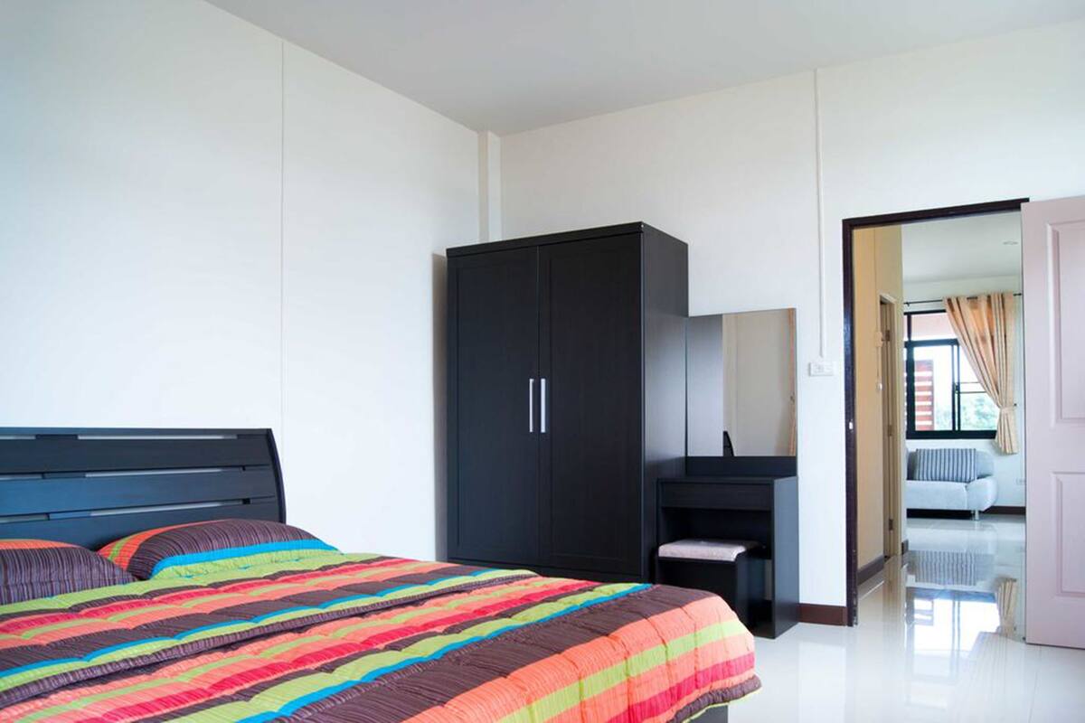 Ein Schlafzimmer mit Bett, Kleiderschrank und Schreibtisch.