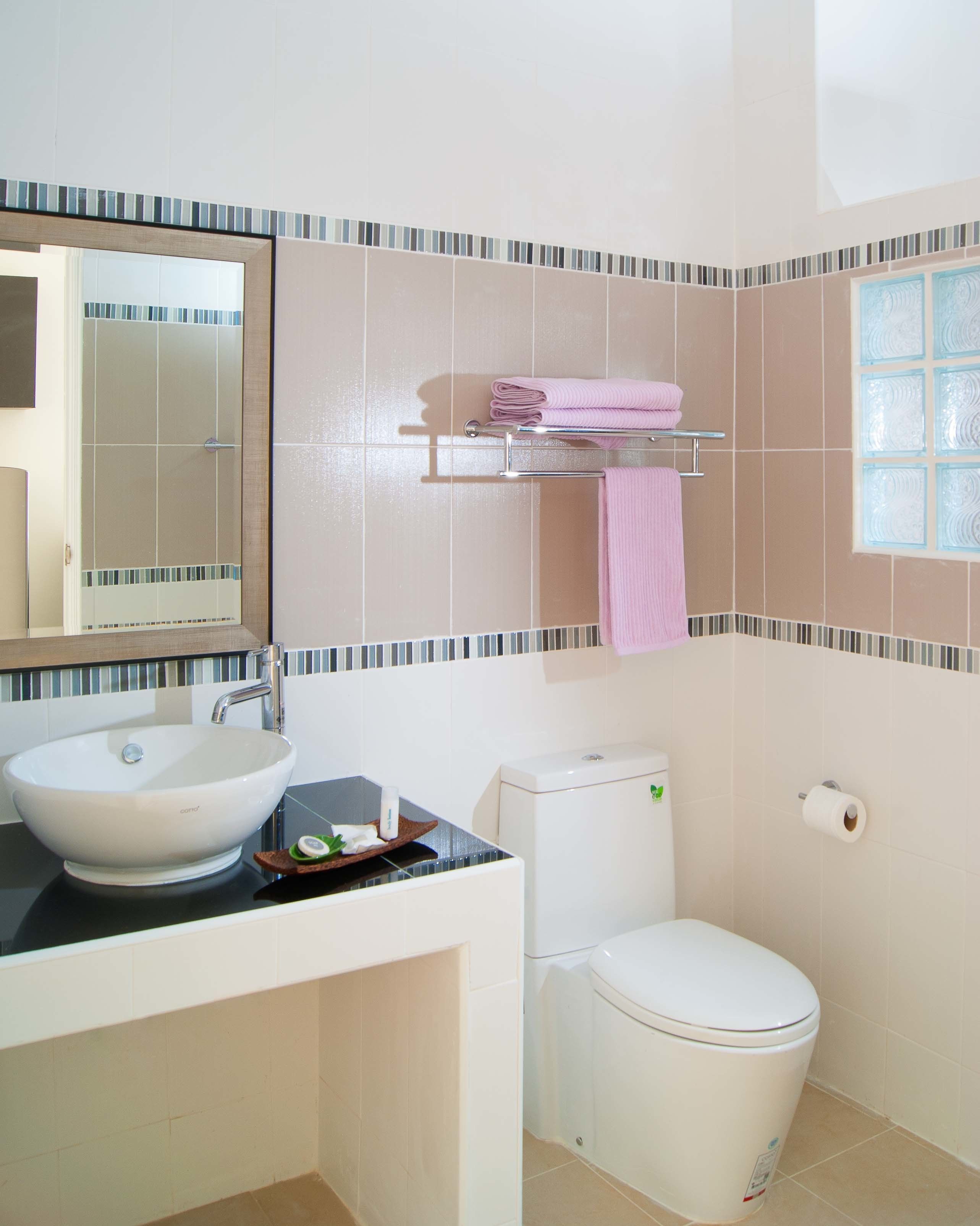 A bathroom with a white sink, a toilet, and a mirror.