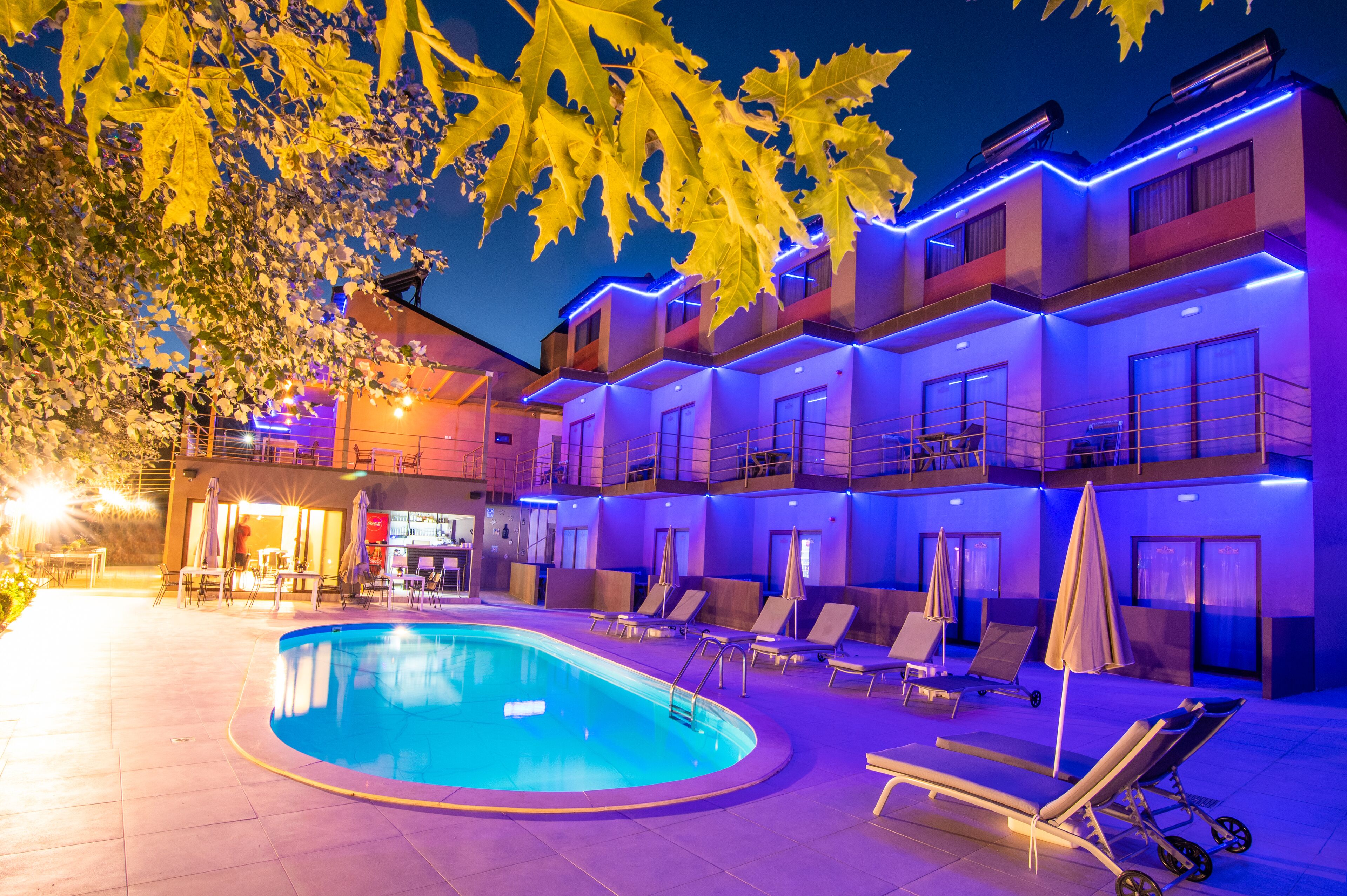 Un hôtel doté d’une piscine, de chaises longues et de parasols.