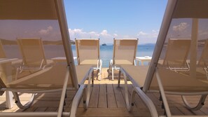 A deck with two lounge chairs facing a calm sea and a ship in the distance. - Eda Motel (Bodrum)