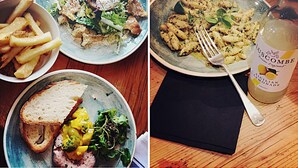 A dining table with four plates of food, a bottle of lemon juice, and a napkin.